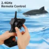Main tenant une télécommande 2.4GHz avec un requin télécommandé dans l'eau en arrière-plan.