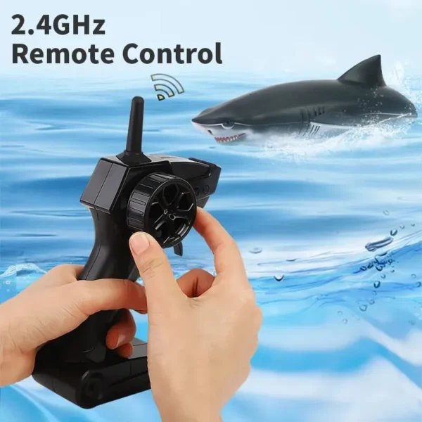 Main tenant une télécommande 2.4GHz avec un requin télécommandé dans l'eau en arrière-plan.